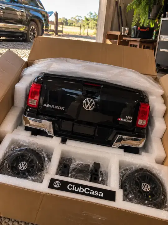 Cliente abrindo a caixa de papelão com o ClubCasa da Amarok