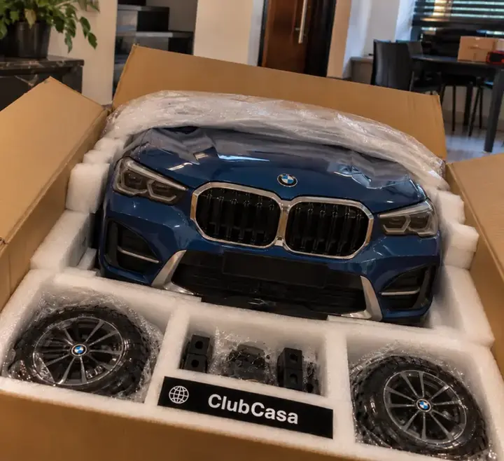 Cliente desembalando o ClubCasa com a BMW X1 azul em casa